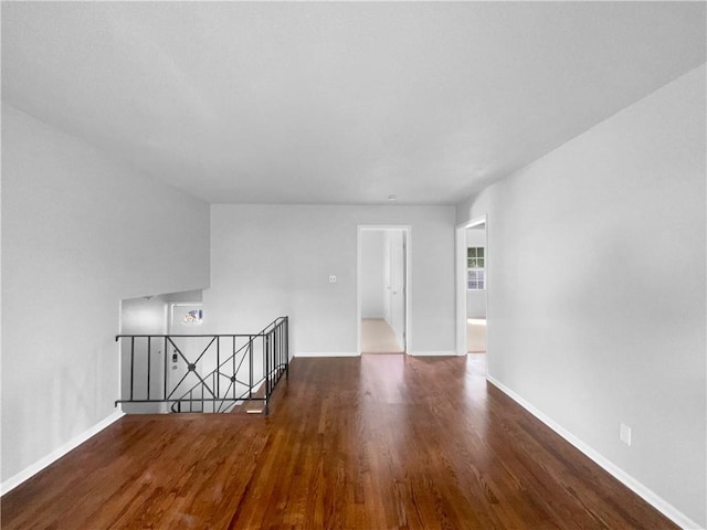 empty room with baseboards and wood finished floors