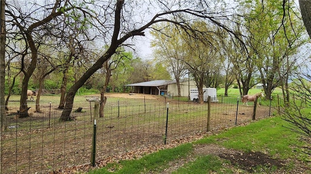view of yard featuring fence, an outdoor structure, and a pole building