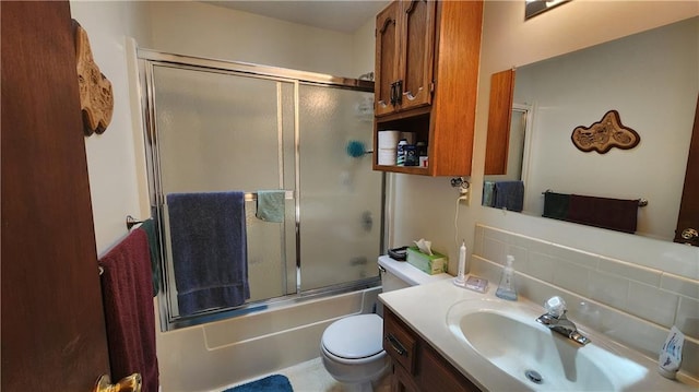 bathroom featuring vanity, toilet, and shower / bath combination with glass door