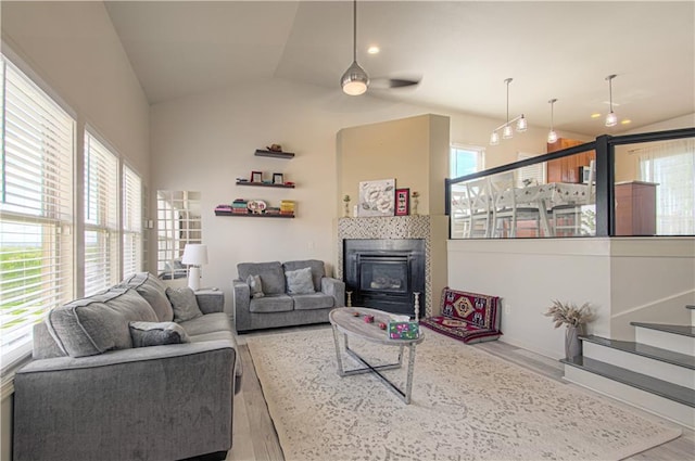 4515 67th Ter, Kansas City, MO 64119 - living area with wood finished floors, a ceiling fan, lofted ceiling, healthy amount of natural light, and a tiled fireplace