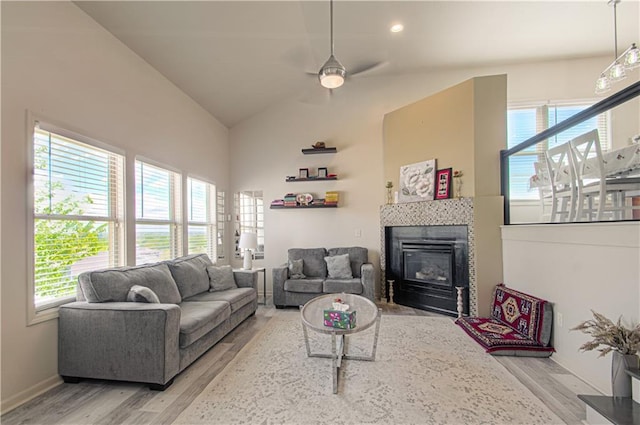 4515 67th Ter, Kansas City, MO 64119 - living room with light wood-style flooring, healthy amount of natural light, a tile fireplace, ceiling fan, and vaulted ceiling
