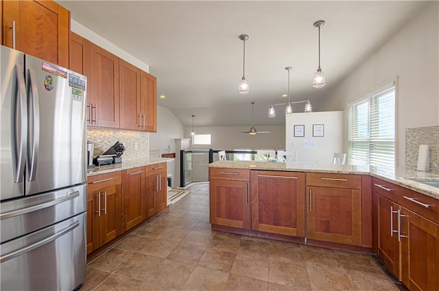 4515 67th Ter, Kansas City, MO 64119 - kitchen with freestanding refrigerator, backsplash, a peninsula, brown cabinets, and lofted ceiling
