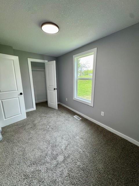 403 W Cedar St, Waverly, MO 64096 - unfurnished bedroom with baseboards, a closet, a textured ceiling, and carpet floors