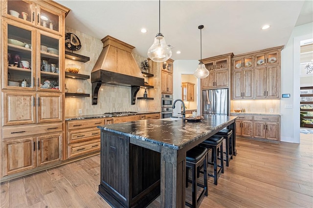 kitchen with a breakfast bar area, a large island, tasteful backsplash, light wood-style floors, and stainless steel appliances