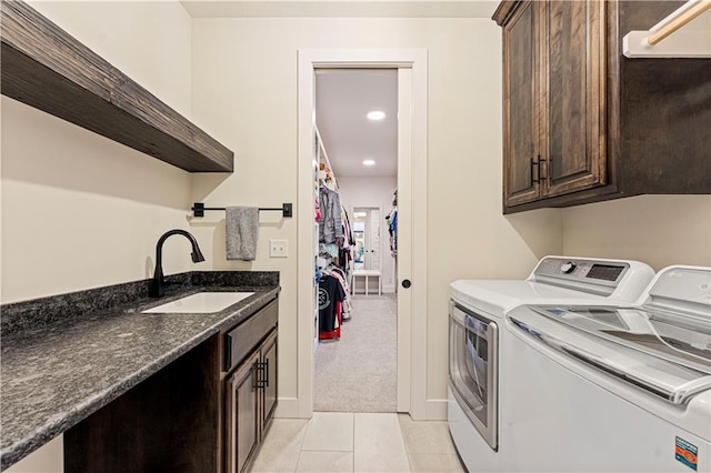 clothes washing area featuring cabinet space, a sink, light tile patterned floors, separate washer and dryer, and light carpet