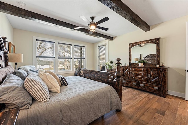 bedroom featuring baseboards, a ceiling fan, wood finished floors, and beamed ceiling