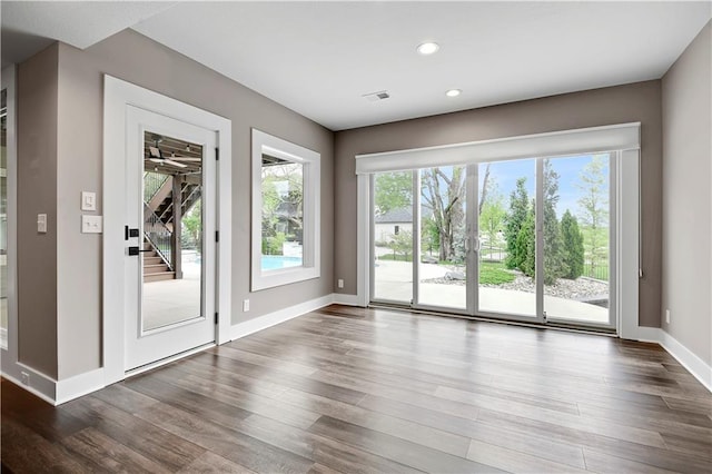 doorway to outside featuring recessed lighting, baseboards, a wealth of natural light, and wood finished floors