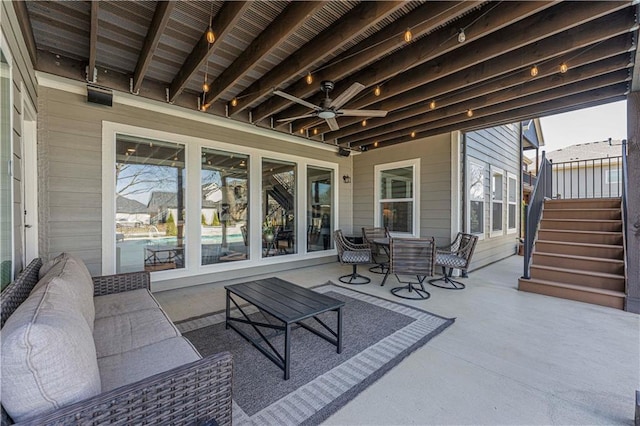 view of patio / terrace featuring ceiling fan and stairway