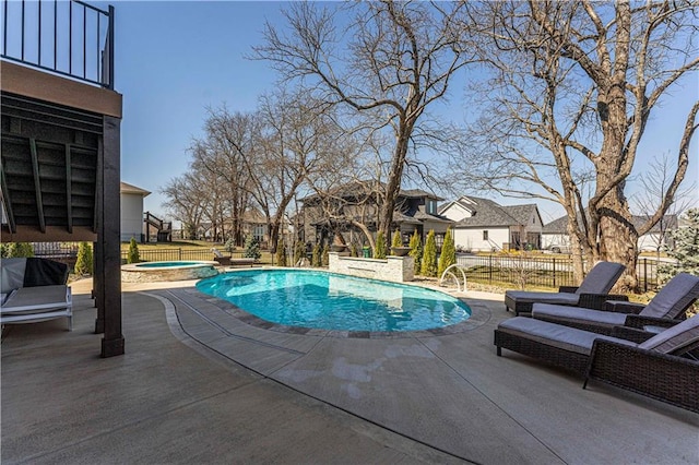 view of pool with a residential view, fence, a pool with connected hot tub, and a patio area
