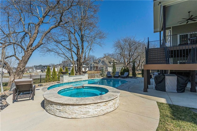 view of swimming pool featuring fence, a patio, a fenced in pool, a ceiling fan, and an in ground hot tub