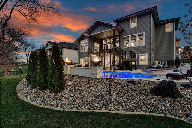 back of property with fence, a patio, stairs, a ceiling fan, and a pool with connected hot tub