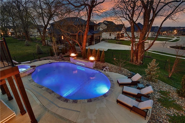 pool at dusk with a lawn, a fenced backyard, a patio area, and a pool with connected hot tub