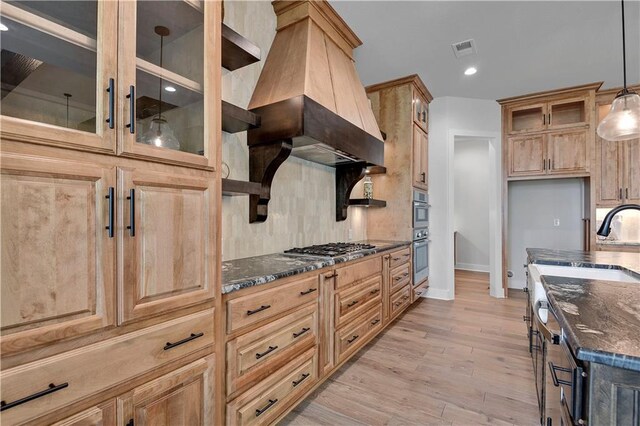 11212 W 170th Pl, Overland Park, KS 66221 - kitchen with dark stone counters, stainless steel appliances, glass insert cabinets, baseboards, and light wood-style flooring