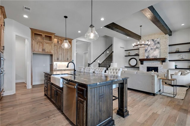 11212 W 170th Pl, Overland Park, KS 66221 - kitchen featuring appliances with stainless steel finishes, a kitchen bar, a sink, baseboards, and light wood finished floors
