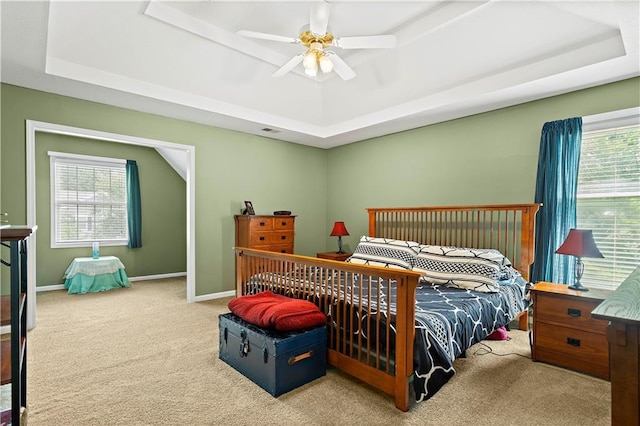 bedroom with ceiling fan, carpet, baseboards, and a raised ceiling