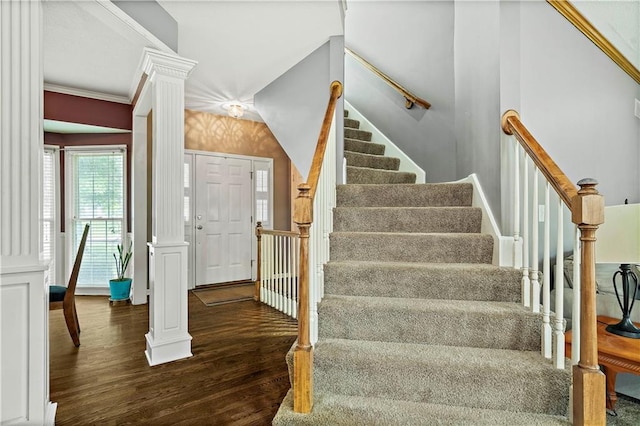stairway featuring decorative columns and wood finished floors