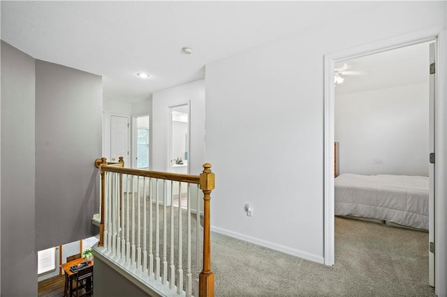 hall featuring recessed lighting, baseboards, an upstairs landing, and carpet