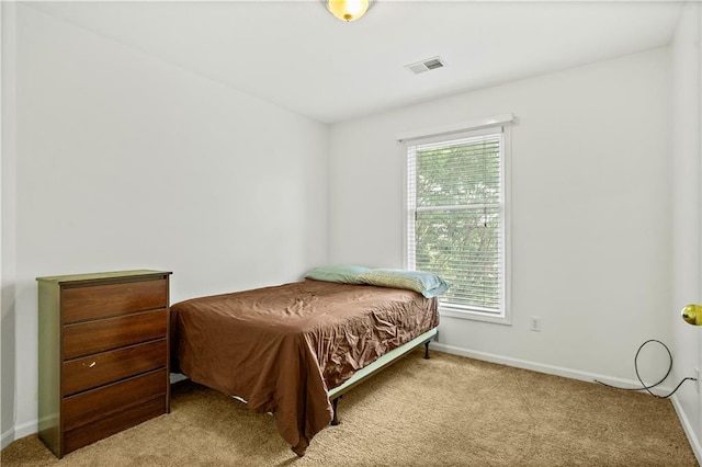 bedroom featuring carpet flooring, visible vents, and multiple windows