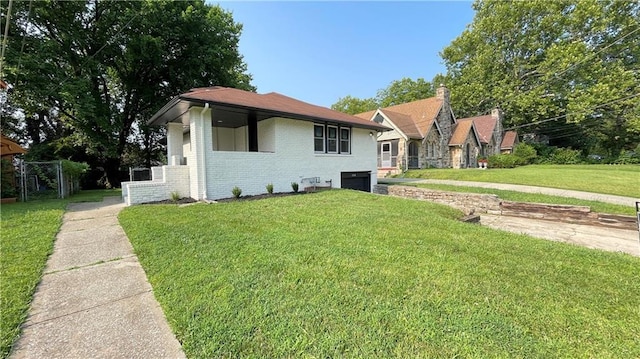 view of front facade with brick siding, a garage, and a front lawn