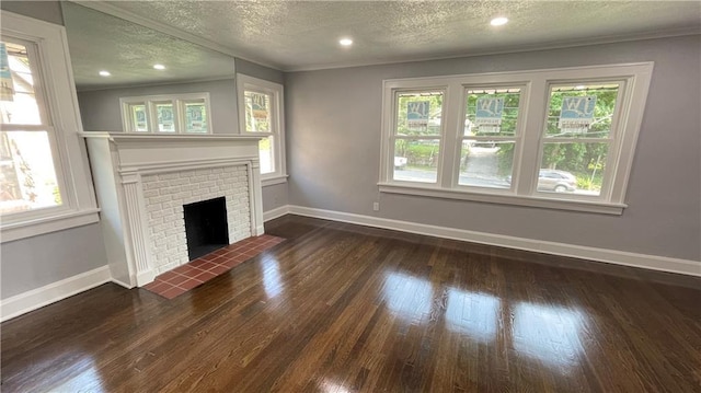 unfurnished living room featuring wood finished floors, a textured ceiling, and a wealth of natural light