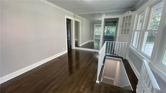 spare room featuring baseboards, ornamental molding, and wood finished floors