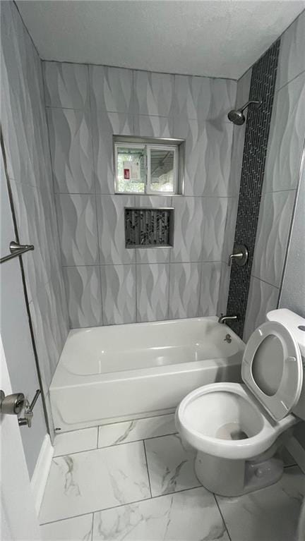 full bathroom featuring a textured ceiling, toilet, shower / tub combination, and marble finish floor