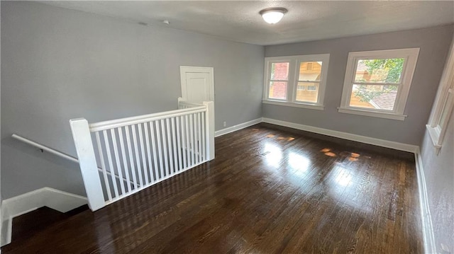 empty room featuring baseboards and wood finished floors