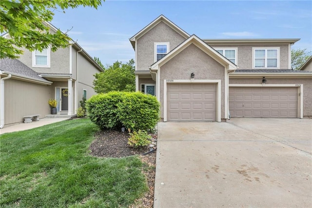 view of front facade with stucco siding, driveway, and a front yard