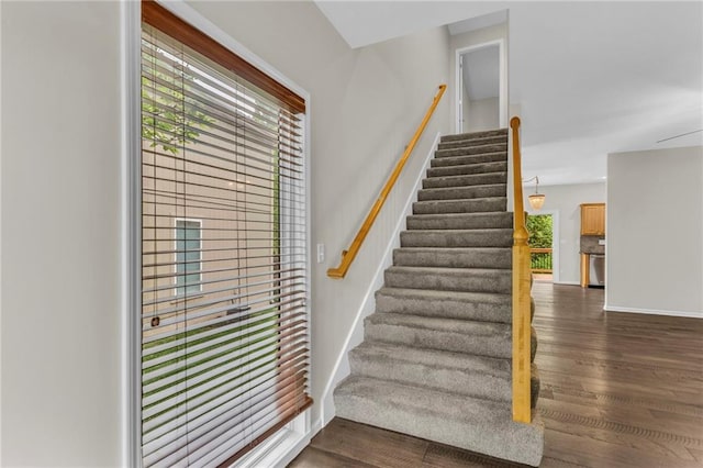 staircase with baseboards and wood finished floors