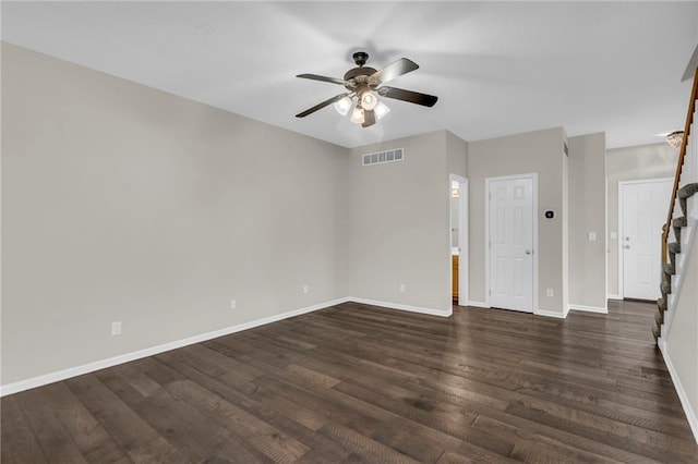 empty room with baseboards, ceiling fan, dark wood-type flooring, and visible vents