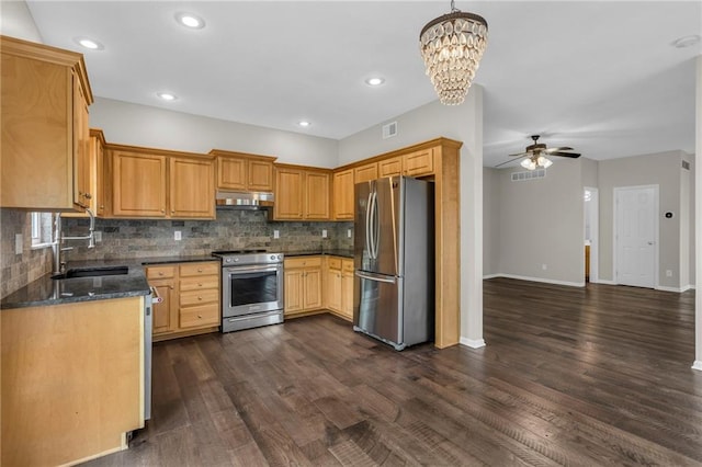 kitchen with visible vents, under cabinet range hood, a sink, ceiling fan with notable chandelier, and stainless steel appliances