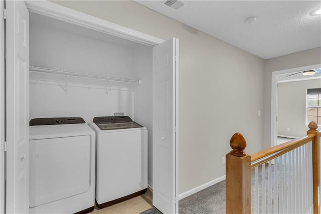 clothes washing area with laundry area, baseboards, visible vents, and washing machine and clothes dryer