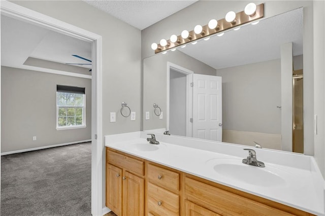 bathroom with double vanity, baseboards, and a sink