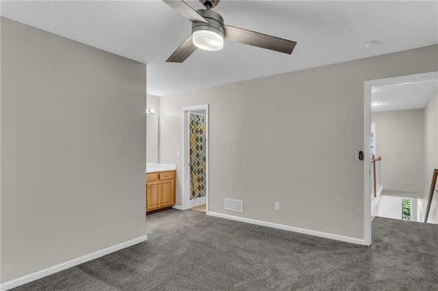 unfurnished bedroom featuring carpet flooring, connected bathroom, a ceiling fan, baseboards, and visible vents