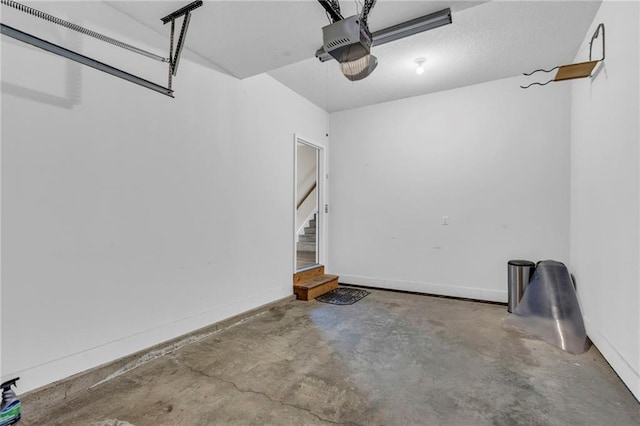 garage with baseboards and a garage door opener