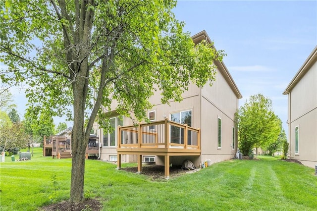 back of property with a yard and a deck