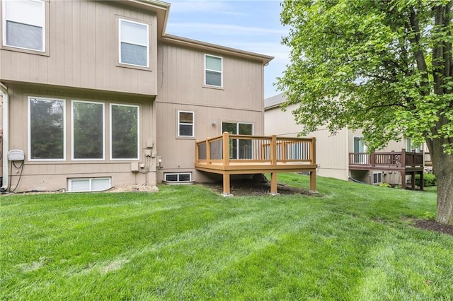 back of house featuring a lawn and a deck