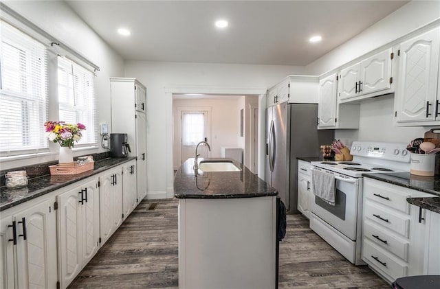 kitchen with white range with electric stovetop, a sink, white cabinetry, dark wood-type flooring, and a center island with sink
