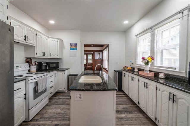 kitchen with dark wood-style flooring, black microwave, a sink, white cabinets, and white range with electric stovetop