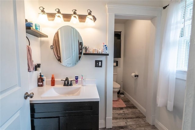 bathroom featuring vanity, baseboards, toilet, and wood finished floors