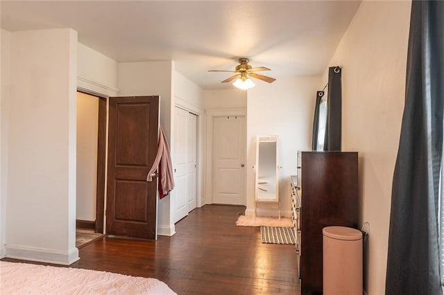 bedroom with baseboards, ceiling fan, and dark wood-type flooring