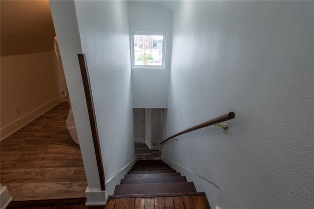 staircase featuring baseboards and wood finished floors