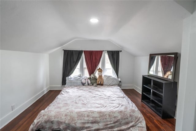 bedroom featuring baseboards, lofted ceiling, and wood finished floors