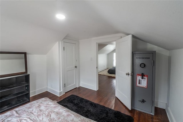 bedroom with baseboards, dark wood-style floors, and lofted ceiling