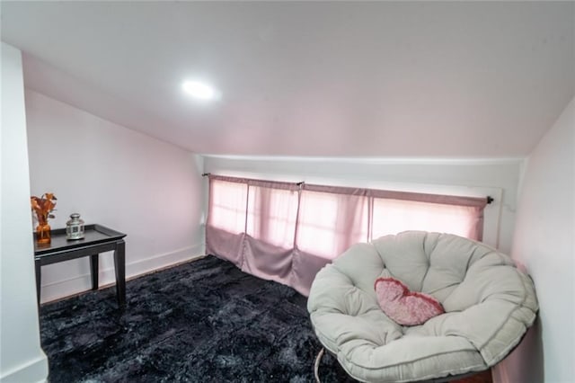 sitting room featuring baseboards and dark carpet