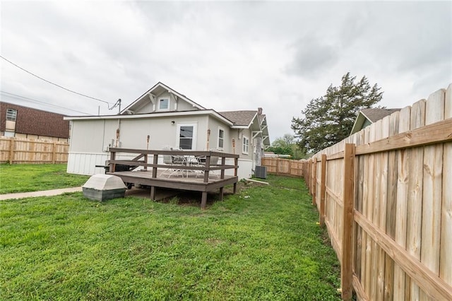 back of house with a fenced backyard, a wooden deck, a yard, and central air condition unit