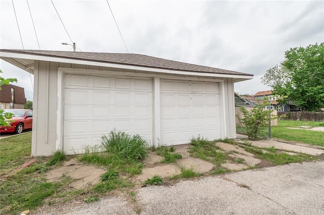 detached garage featuring fence