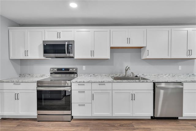512 W 6th St, Carrollton, MO 64633 - kitchen with light stone countertops, recessed lighting, white cabinetry, a sink, and appliances with stainless steel finishes