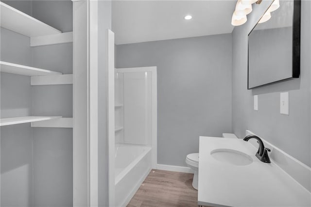 512 W 6th St, Carrollton, MO 64633 - bathroom featuring vanity, toilet, recessed lighting, baseboards, and wood finished floors