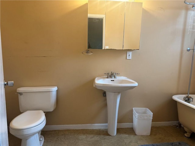 full bath featuring toilet, a bath, baseboards, tile patterned floors, and a sink
